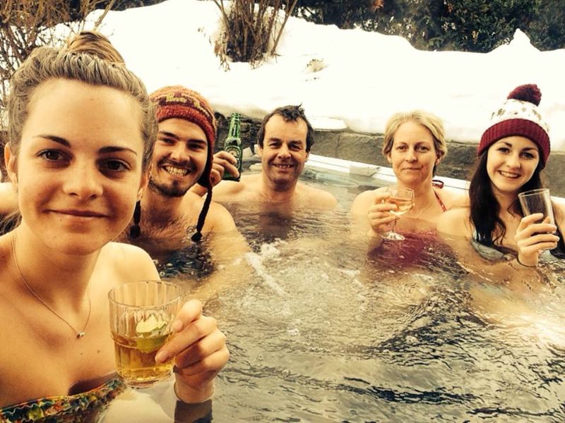 A group of friends enjoying a ski chalet hot tub in the Alps